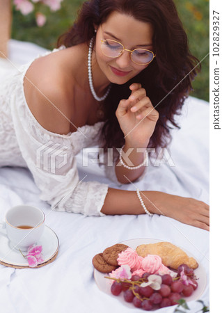 Romantic British Bride Enjoys Baked Treats in Park 102829327
