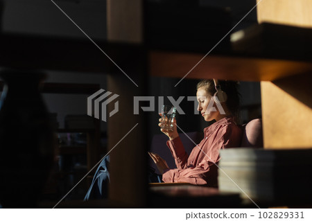 Young woman having break during work, listening music. 102829331