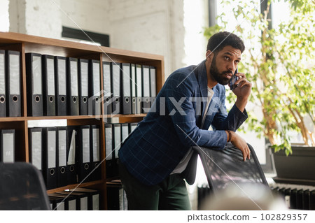 Multiracial man having call in his office. Multiracial man having call in his office. 102829357
