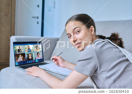Video conference, laptop screen with group of students and teacher, teen girl looking at camera 102830410