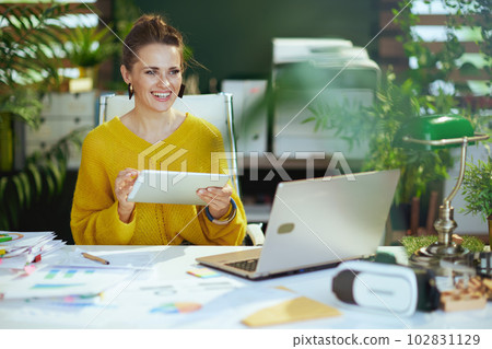 smiling business owner woman in sweater in green office smiling business owner woman in sweater in green office 102831129
