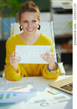 happy elegant business owner woman in sweater in green office 102831130