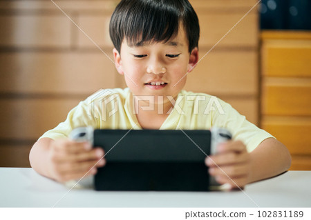 在家用視頻遊戲機上玩遊戲的小學生 102831189