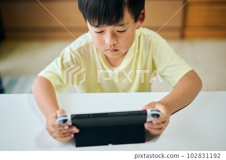 在家用視頻遊戲機上玩遊戲的小學生 102831192