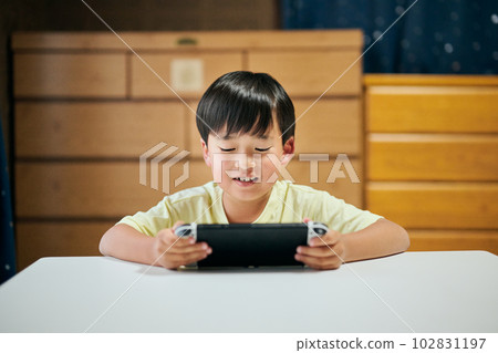 Elementary school boy playing a game on a home video game console Elementary school boy playing a game on a home video game console 102831197