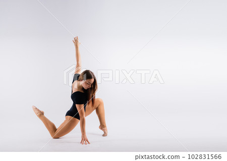 Flexible girl, rhythmic gymnastics artist jumping on white dark background. Grace in motion, action. 102831566