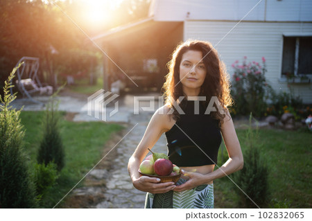 young woman hold bowl with apples and pears, harvest gathering 102832065