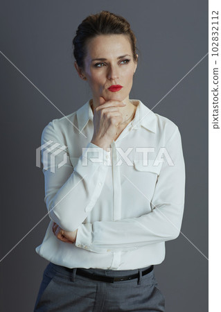 pensive modern woman employee against grey background 102832112