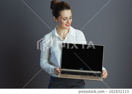 smiling business owner woman showing laptop blank screen smiling business owner woman showing laptop blank screen 102832113