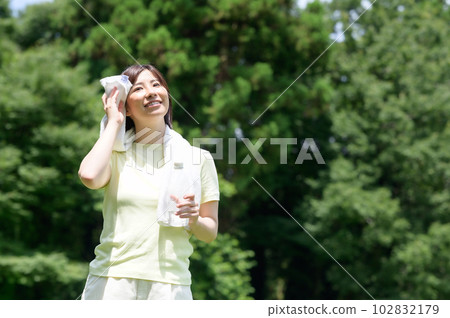Woman with towel and water in the park Woman with towel and water in the park 102832179