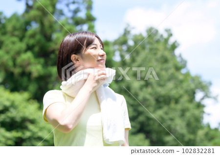 Woman holding a towel in the park 102832281
