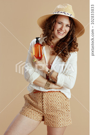 smiling housewife in blouse and shorts on beige 102833833