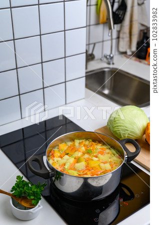 Cooking Bright Vegetable Soup on the Stove Cooking Bright Vegetable Soup on the Stove 102833982