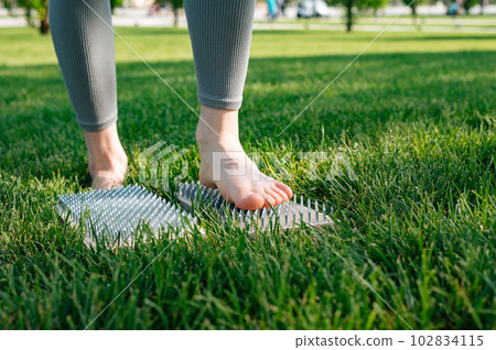 The girl stands on the nails. Sadhu wooden board for yoga practice. Nailing practice The girl stands on the nails. Sadhu wooden board for yoga practice. Nailing practice 102834115