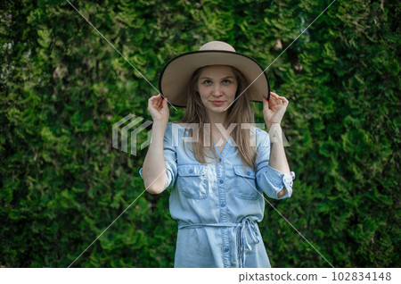 The girl dreams of a new apartment. Romantic girl with hat on picnic in park. The girl dreams of a new apartment. Romantic girl with hat on picnic in park. 102834148