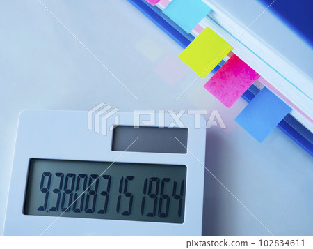 A blue file and a calculator on the table A blue file and a calculator on the table 102834611
