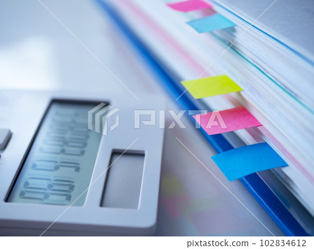 A blue file and a calculator on the table A blue file and a calculator on the table 102834612