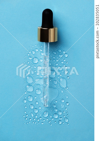 Drops of face serum top view. Liquid gel moisturizer. Creative idea of face serum with pipette on blue background. 102835051