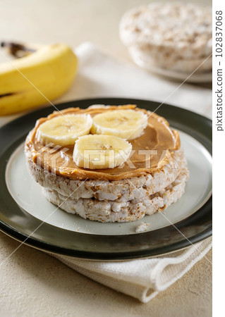 Rice cake with banana and peanut butter, healthy protein snack. Rice cake with banana and peanut butter, healthy protein snack. 102837068