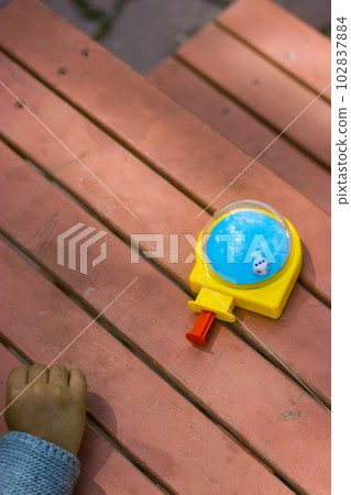 Eduk8 mini cube is a developmental toy for children. A game to develop fine motor skills in pre-school children. Childhood A child is playing with a colorful toy outdoors on playground Selective focus Eduk8 mini cube is a developmental toy for children. A game to develop fine motor skills in pre-school children. Childhood A child is playing with a colorful toy outdoors on playground Selective focus 102837884