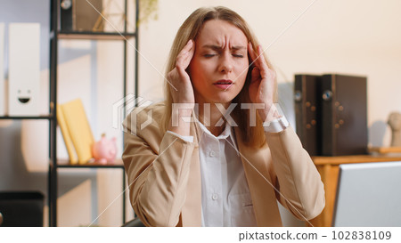 Tired sleepy business woman suffering from headache problem tension, migraine, stress at home office Tired sleepy business woman suffering from headache problem tension, migraine, stress at home office 102838109