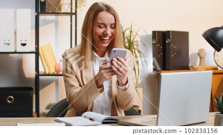 Businesswoman shocked by sudden victory on smartphone game winning lottery goal achievemen good news 102838156