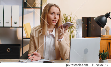 Young business woman working, having mobile phone talk at office workplace using messenger chat apps Young business woman working, having mobile phone talk at office workplace using messenger chat apps 102838157