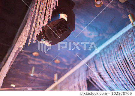 Installation of professional sound, light, video and stage equipment for a concert. Stage lighting equipment is clamped on a truss for lifting. Flight cases with cables. 102838709