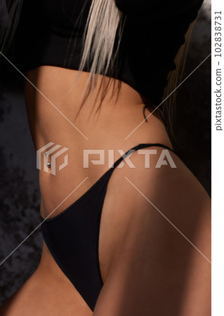 Slender narrow waist.Close up strong abdominal muscles of a young sporty woman. 102838731