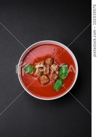Delicious fresh gazpacho with breadcrumbs, salt and spices in a ceramic plate 102838978