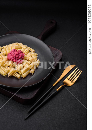 Delicious fusilli pasta with beetroot pesto, parmesan, salt and spices 102839021