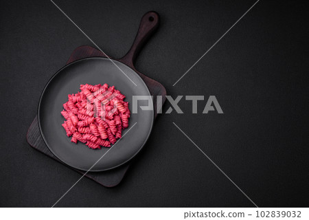 Delicious fusilli pasta with beetroot pesto, parmesan, salt and spices 102839032