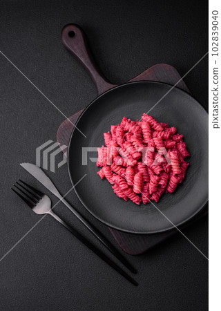 Delicious fusilli pasta with beetroot pesto, parmesan, salt and spices Delicious fusilli pasta with beetroot pesto, parmesan, salt and spices 102839040