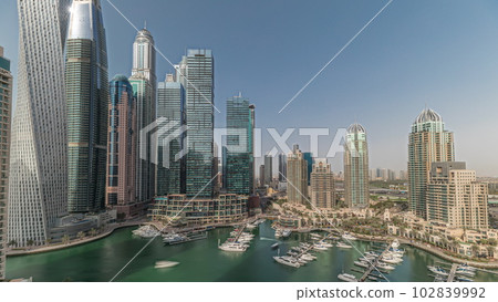 Panorama showing Dubai marina tallest skyscrapers and yachts in harbor aerial timelapse. Panorama showing Dubai marina tallest skyscrapers and yachts in harbor aerial timelapse. 102839992