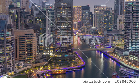 Dubai Marina with several boat and yachts parked in harbor and skyscrapers around canal aerial day to night timelapse. Dubai Marina with several boat and yachts parked in harbor and skyscrapers around canal aerial day to night timelapse. 102840006