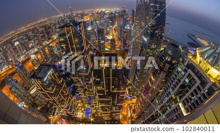Skyline panorama of Dubai Marina showing canal surrounded by skyscrapers along shoreline day to night timelapse. DUBAI, UAE 102840011