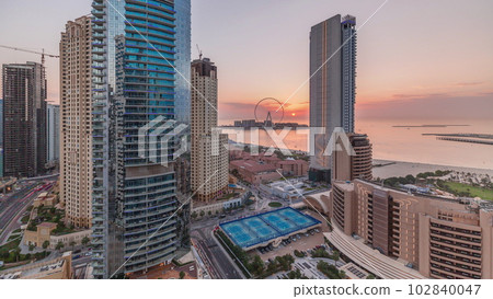 Panoramic sunset view of the Dubai Marina and JBR area and the famous Ferris Wheel aerial timelapse 102840047
