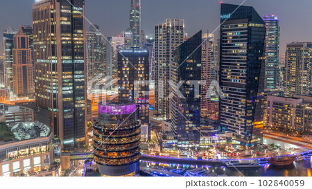 Dubai Marina Skyline with JLT district skyscrapers on a background aerial day to night timelapse. Dubai Marina Skyline with JLT district skyscrapers on a background aerial day to night timelapse. 102840059