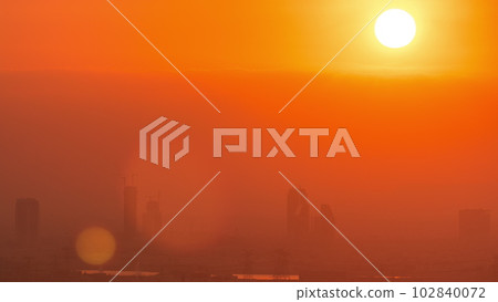 Sunrise over greens and al barsha heights district area night to day timelapse from Dubai marina. Sunrise over greens and al barsha heights district area night to day timelapse from Dubai marina. 102840072