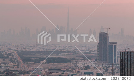 Dubai Downtown skyline row of skyscrapers with tallset tower aerial night to day timelapse. UAE 102840073