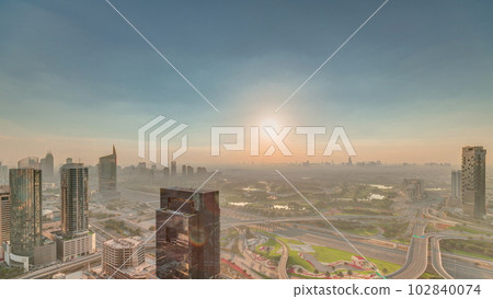 Sunrise over highway junction near media city and al barsha heights district area timelapse from Dubai marina. 102840074
