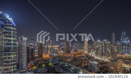Panorama showing Dubai's business bay towers aerial night timelapse. Rooftop view of some skyscrapers Panorama showing Dubai's business bay towers aerial night timelapse. Rooftop view of some skyscrapers 102840128
