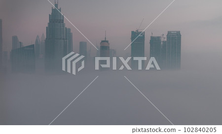 Aerial view morning fog covered Dubai International Financial Centre district night to day timelapse Aerial view morning fog covered Dubai International Financial Centre district night to day timelapse 102840205