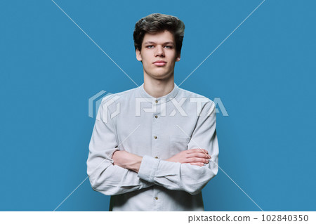 Portrait of young confident serious male on blue background 102840350