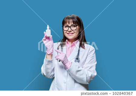 Female doctor with medicine drops for nose eyes ears, on blue background Female doctor with medicine drops for nose eyes ears, on blue background 102840367