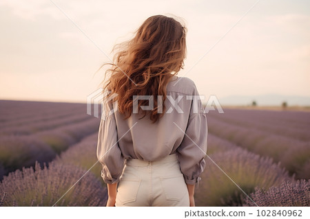 Young pretty woman standing back on the lavender field 102840962