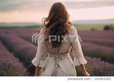 Young pretty woman standing back on the lavender field Young pretty woman standing back on the lavender field 102841001