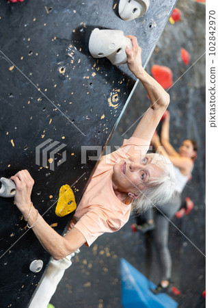 elderly active female pensioner reached top of bouldering wall 102842970