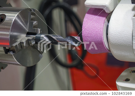 Close up scene the drill tool regrinding process with abrasive stone wheel. 102843169