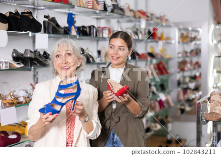 In store,cheerful female friends choose elegant spike heels or high heel sandals In store,cheerful female friends choose elegant spike heels or high heel sandals 102843211